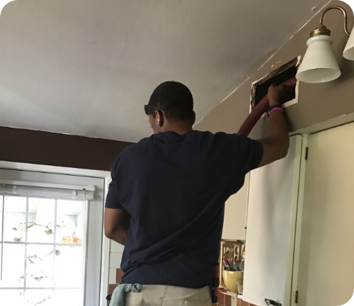cleaning out a vent with a vacuum